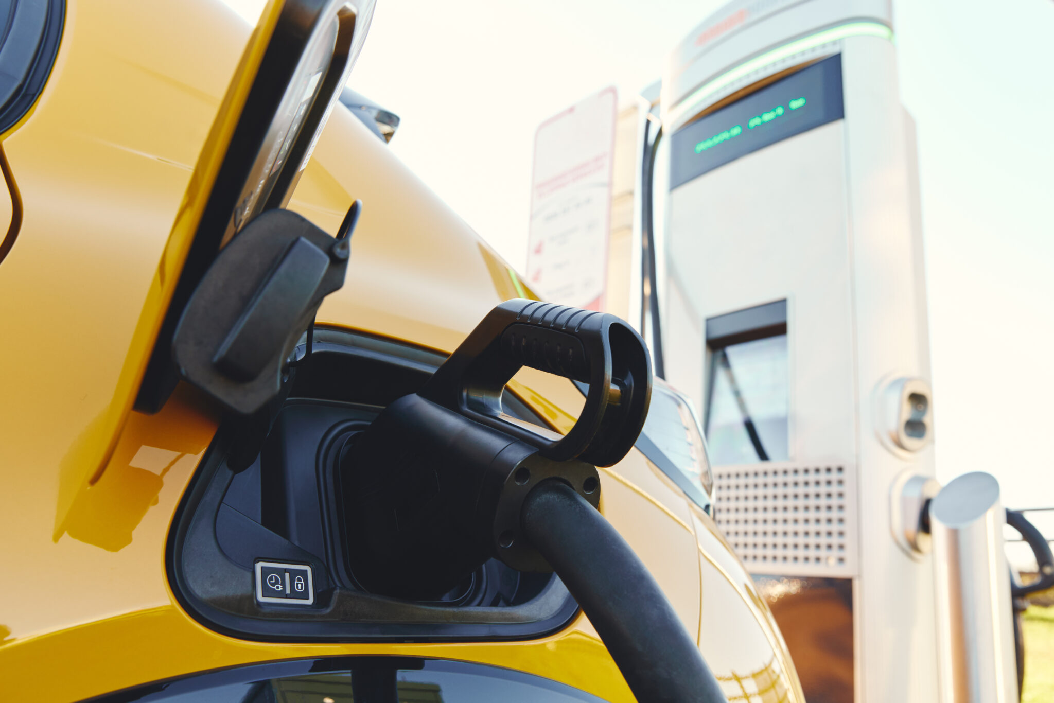 Plugged in electric car in at a EV charging station using a rapid-charger